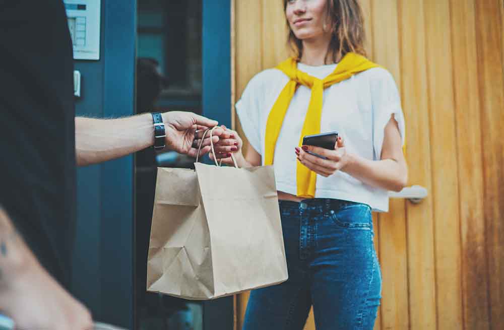 Delivery staff handing bag to customer